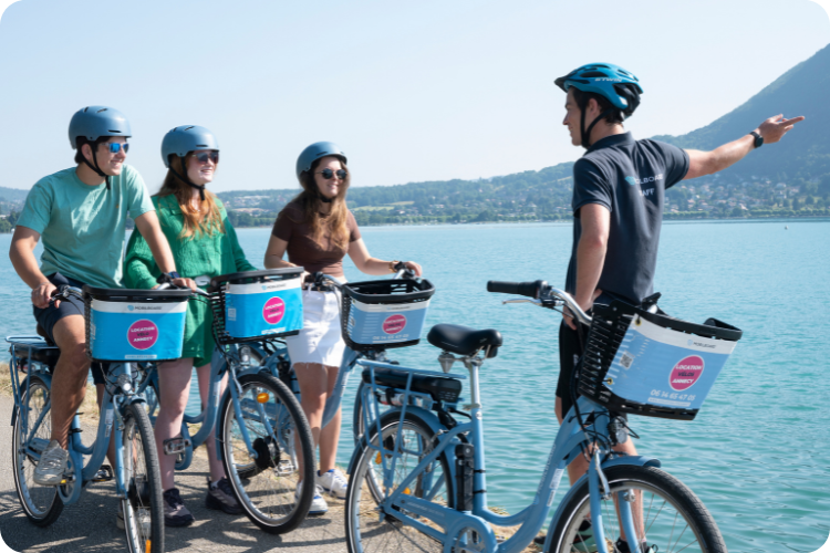 Visite guidée à vélo au bord du lac d'Annecy : un guide Mobilboard et trois cyclistes casqués